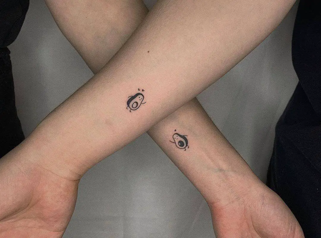 hands with small avocado tattoos