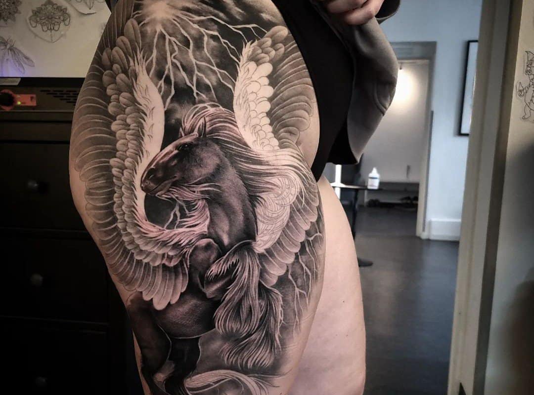 A tattoo of a majestic pegasus with wings spread on his thigh