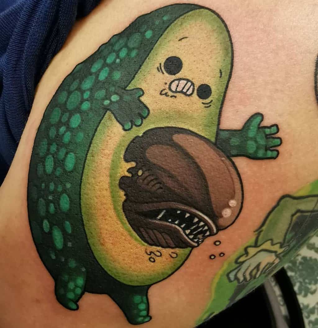 funny avocado tattoo with a alien instead of a bone
