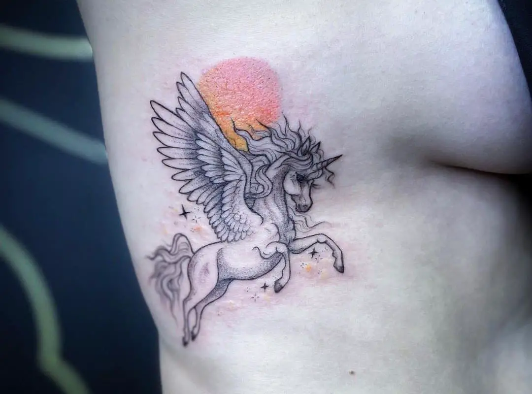 a tattoo of a pegasus flying against the sun