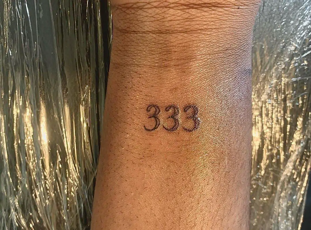 333 tattoo on a woman's hand