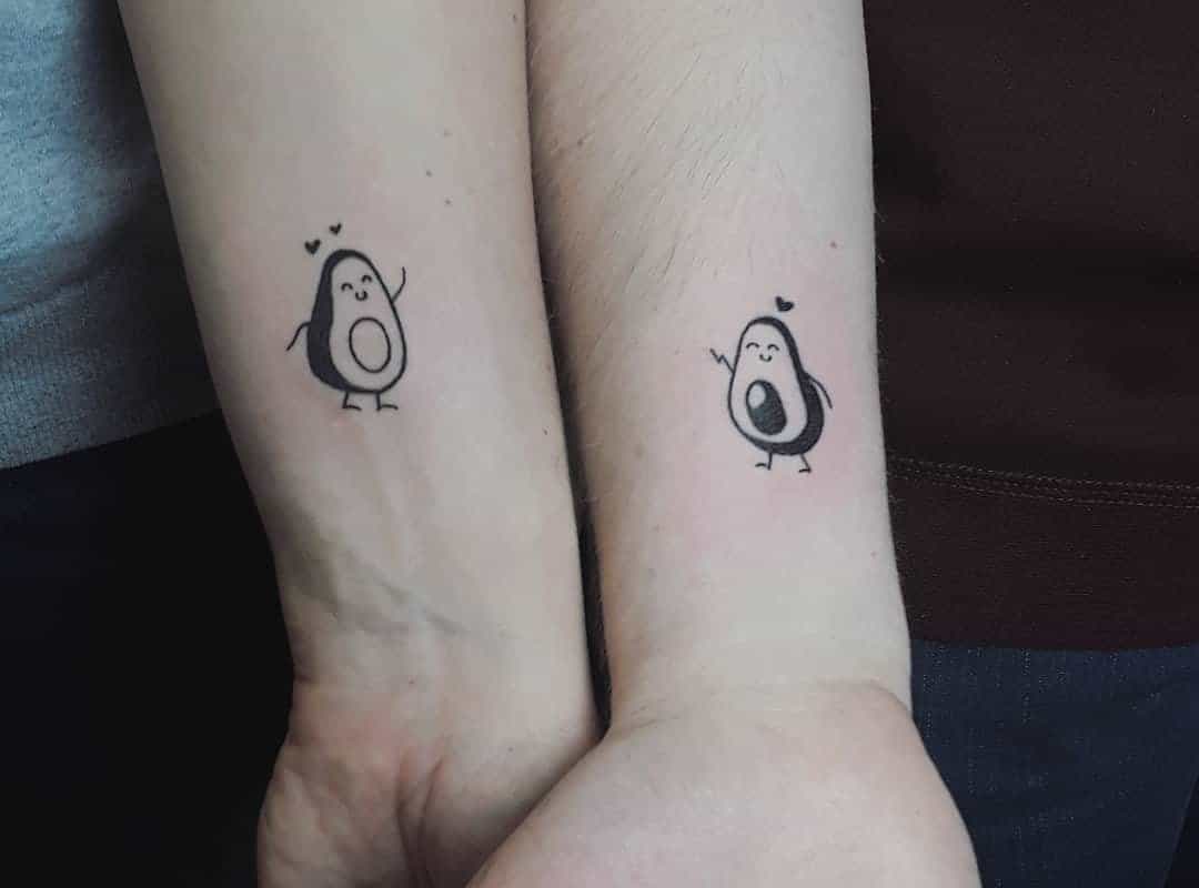 Two hands with avocado tattoos